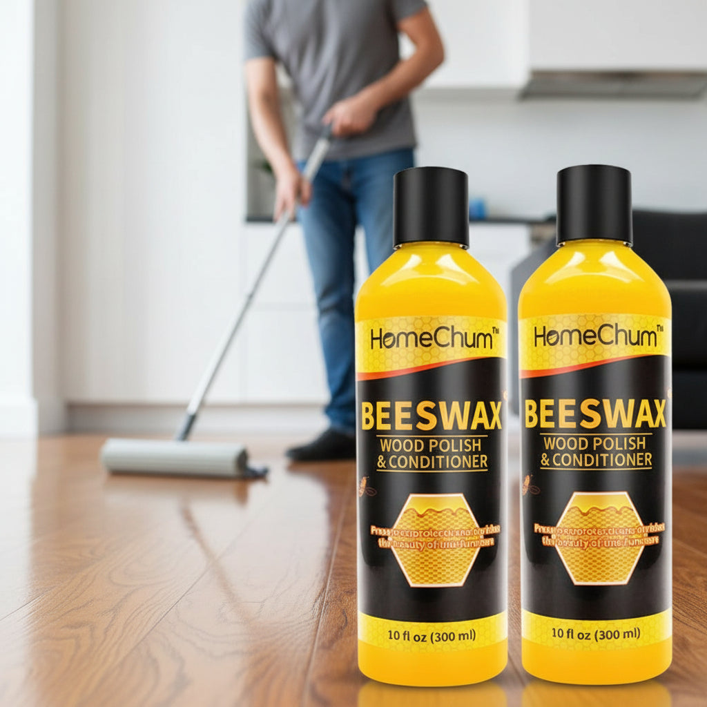 Krombee presents Two bottles of beeswax Wood Polish & Conditioner on a wooden floor while a man mopping the shiny floor with a roller.