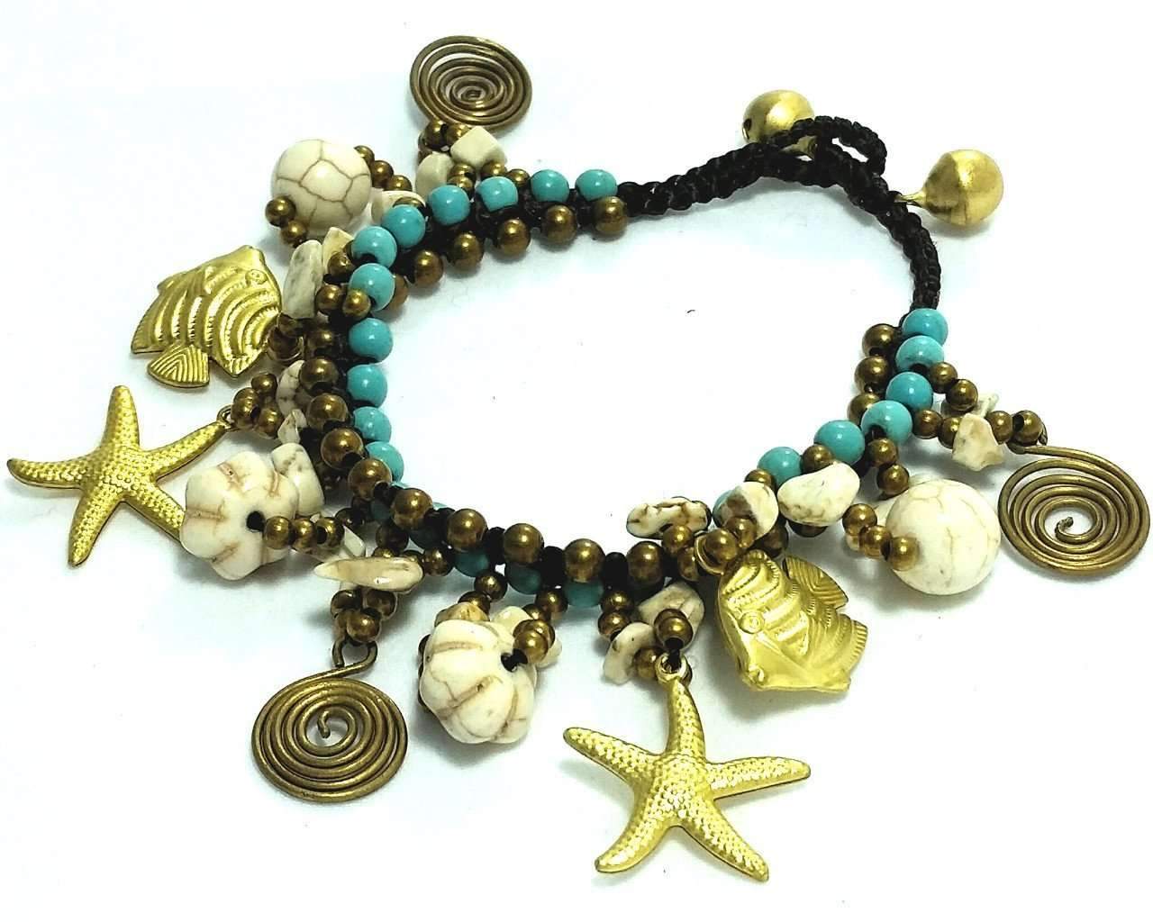 Beaded bracelet with starfish, shell, and fish charms on a white background