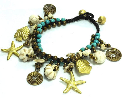 Beaded bracelet with starfish, shell, and fish charms on a white background