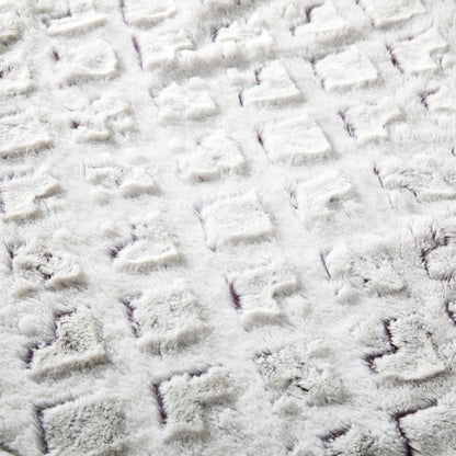 Close-up of embossed faux fur texture with purple undertones.