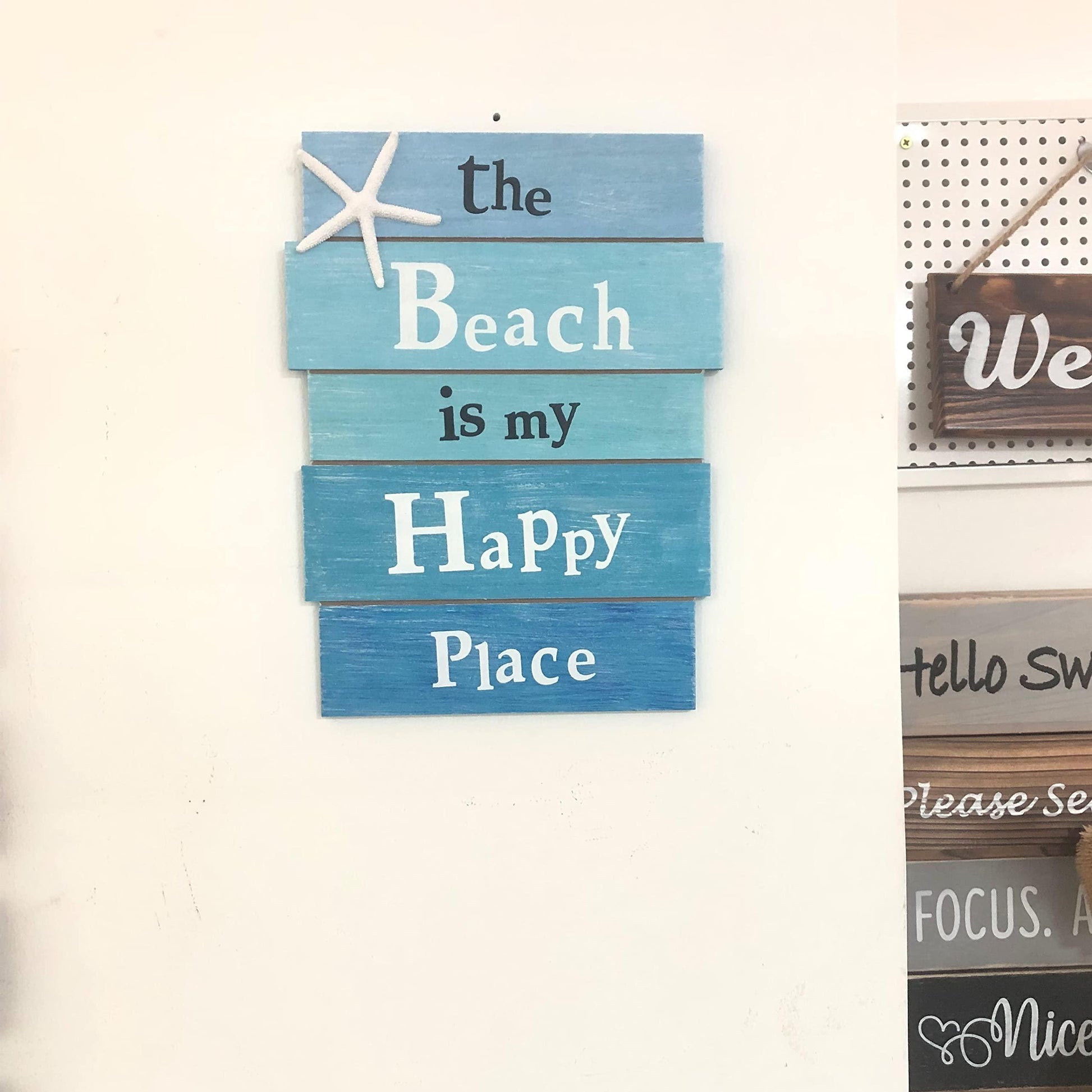 Coastal beach sign with starfish accent hanging on wall