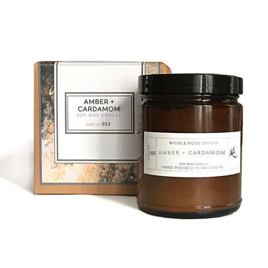 Amber and cardamom candle with packaging on a white background