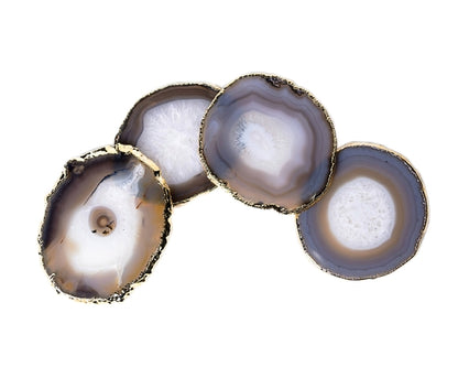 Four agate coasters with golden edges on a white background
