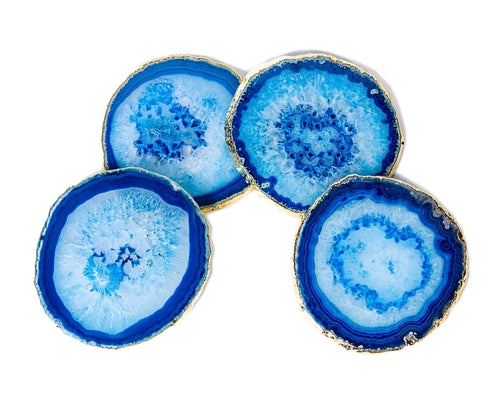 Four blue agate coasters with golden edges on a white background