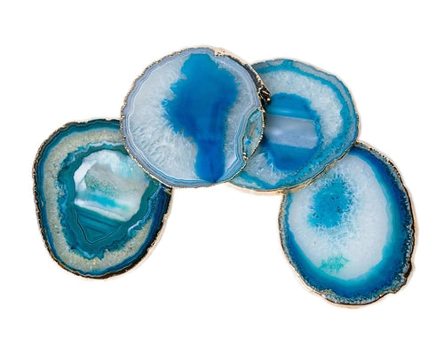 Set of four blue agate coasters with golden trim on a white background
