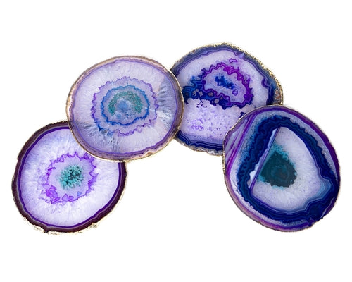 Four large agate slices with purple patterns on a white background