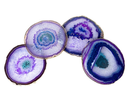 Four large agate slices with purple patterns on a white background
