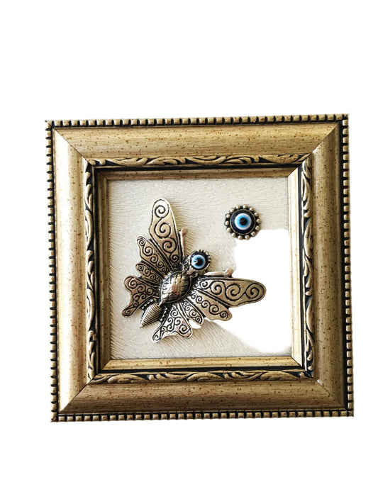 Decorative butterfly wall art in a gold frame on a white background