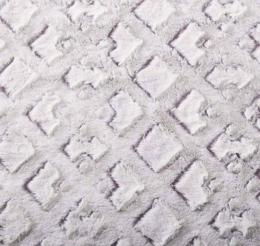 Close-up of plush faux fur fabric showing fluffy purple-and-white details