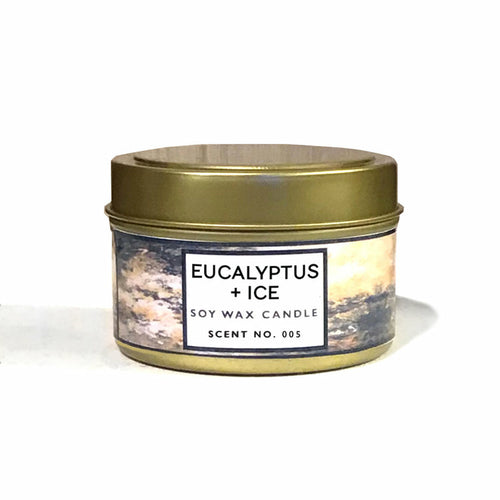 Soy wax candle in a metal tin labeled 'Eucalyptus + Ice' on a white background