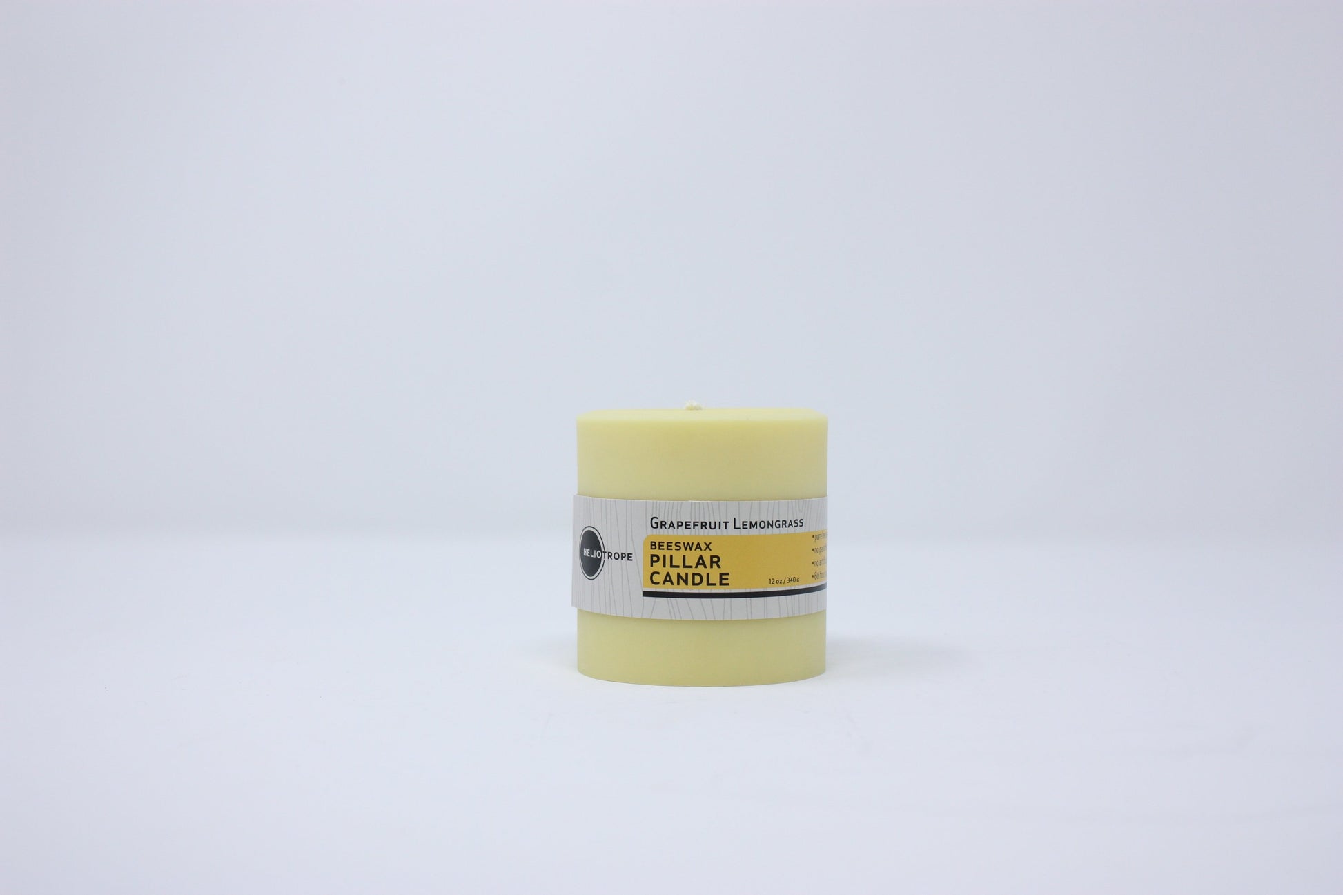 Yellow candle in a cylindrical container on a white background