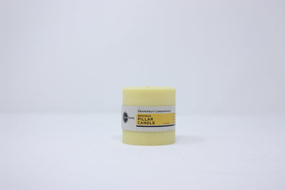 Yellow candle in a cylindrical container on a white background