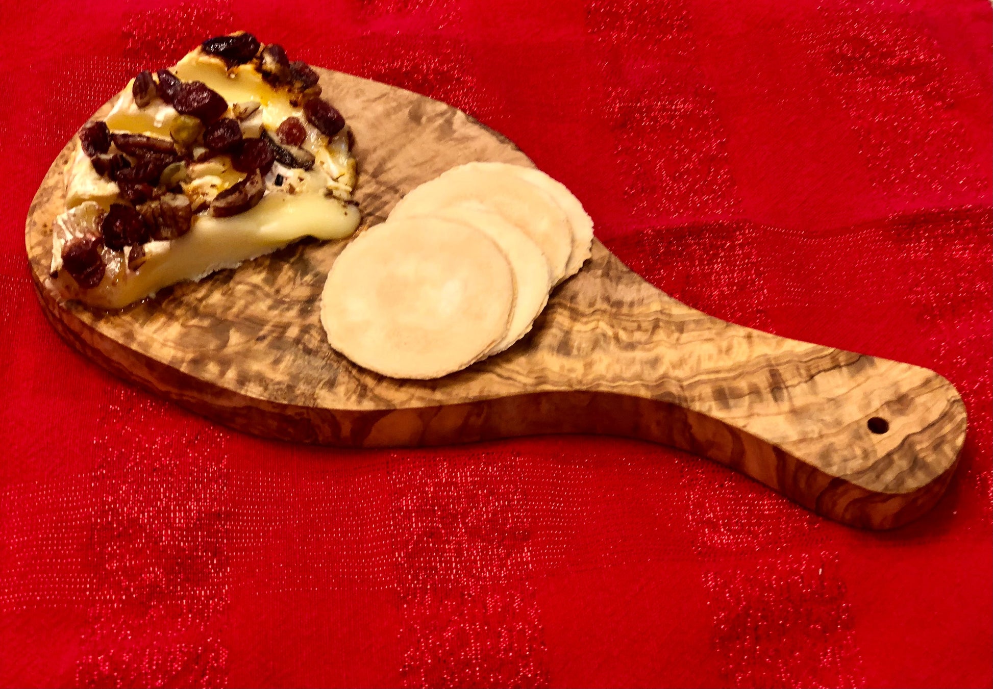 “Olive wood cutting board styled on a kitchen counter for food prep and serving.”