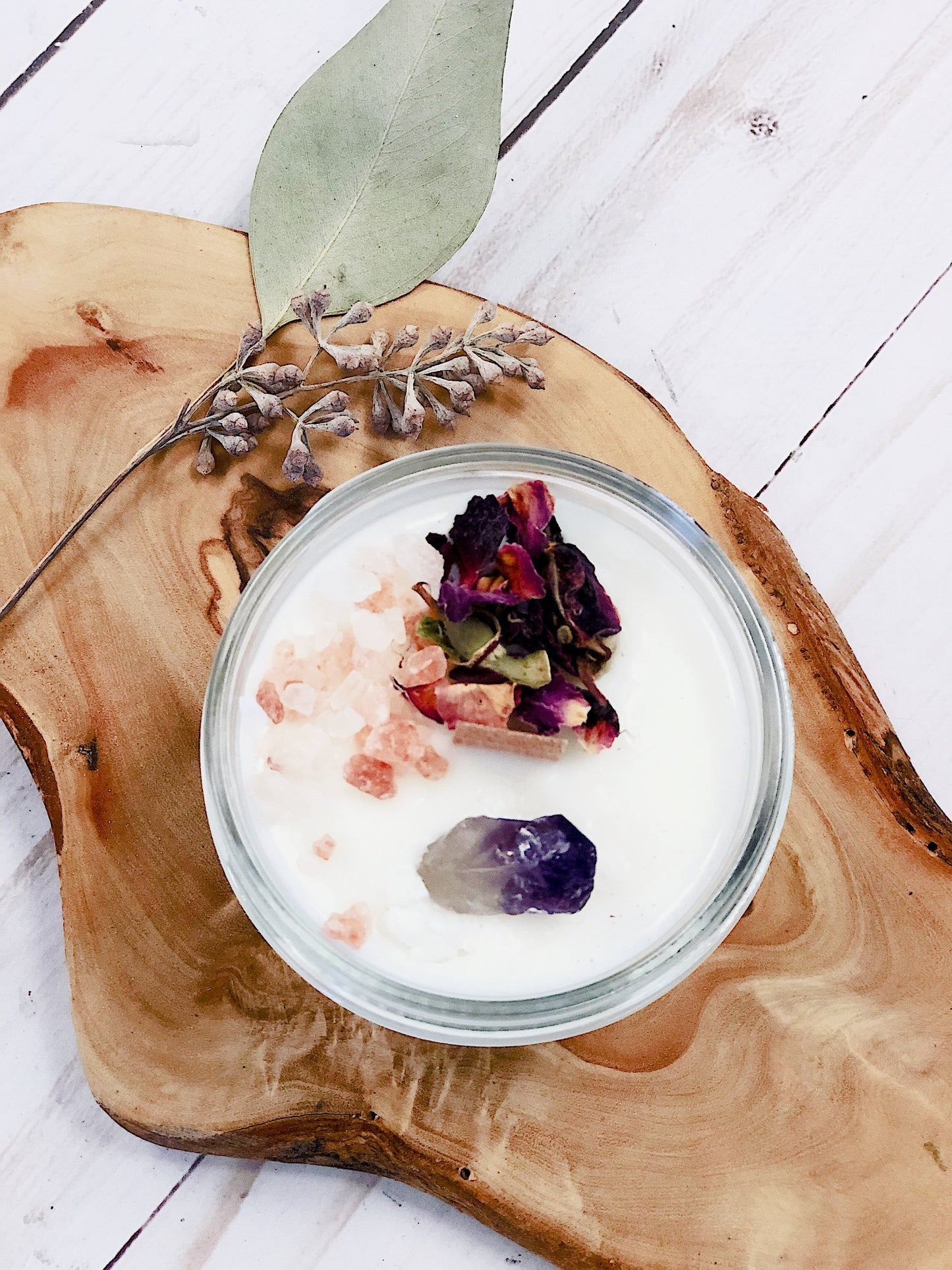 Krombee Remembrance Candle in a glass jar with dried flowers on a wooden surface
