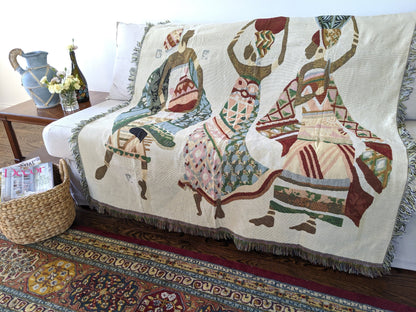 Bohemian-style tapestry throw blanket with colorful tribal design draped over a modern living room sofa – cozy home décor accent