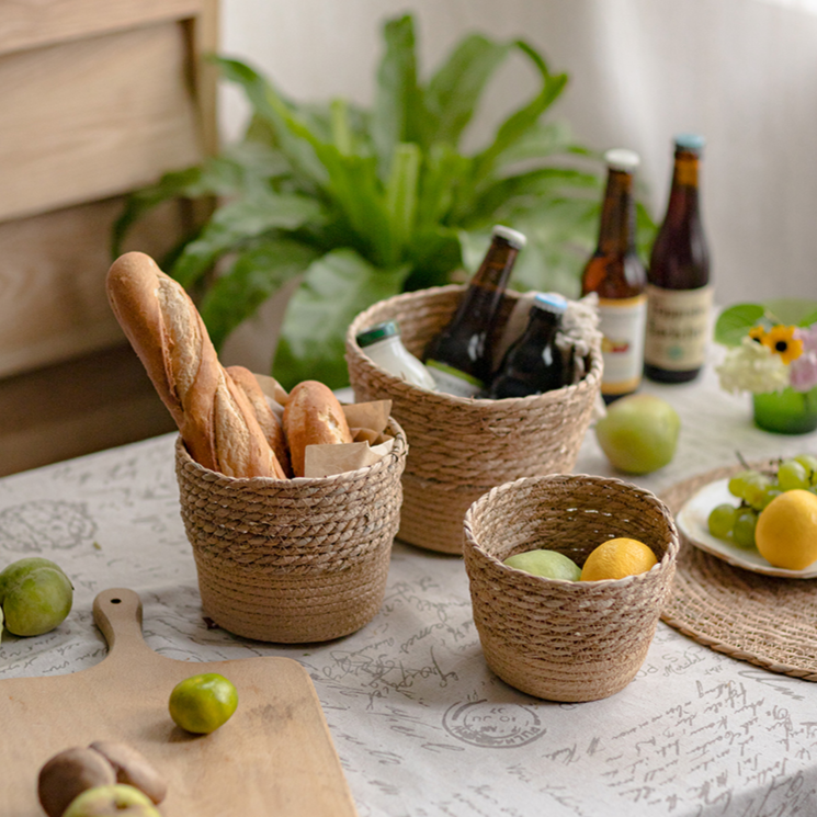 Set of three natural straw desktop baskets in varied sizes