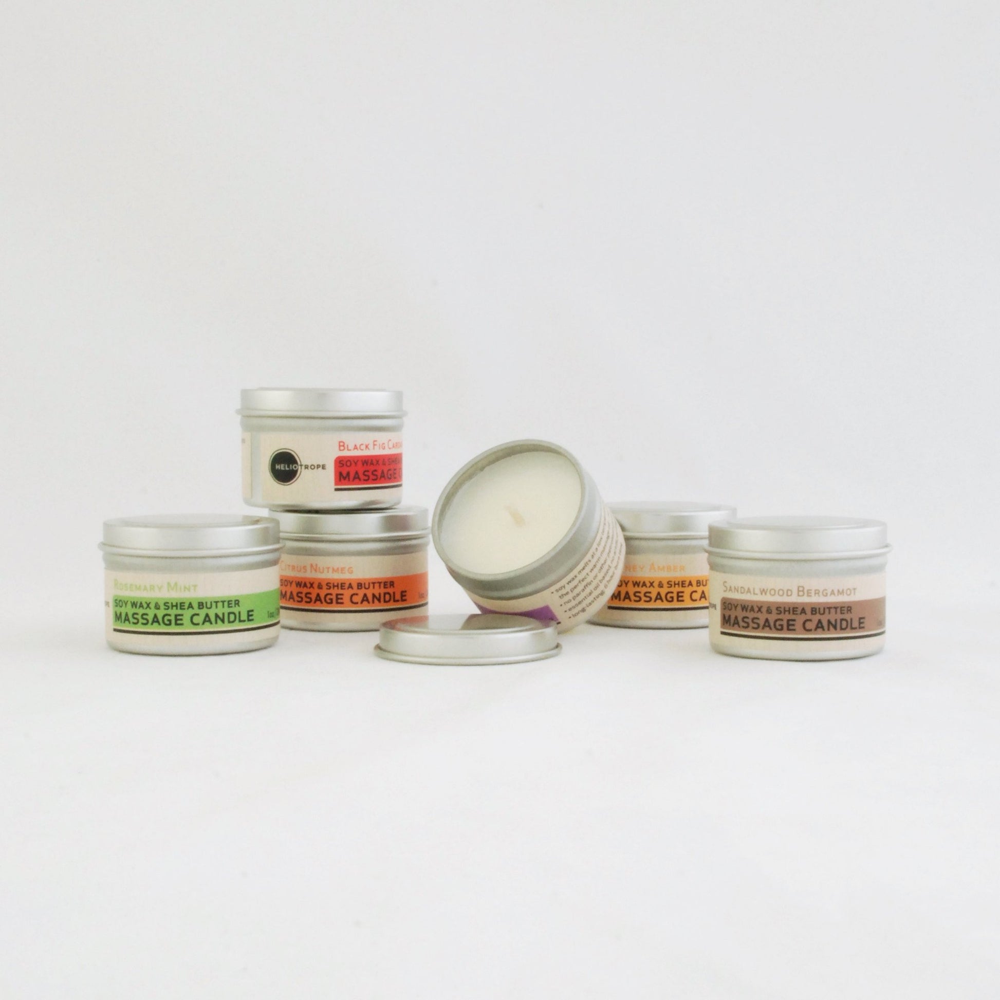 Collection of massage candles with visible labels on a white background