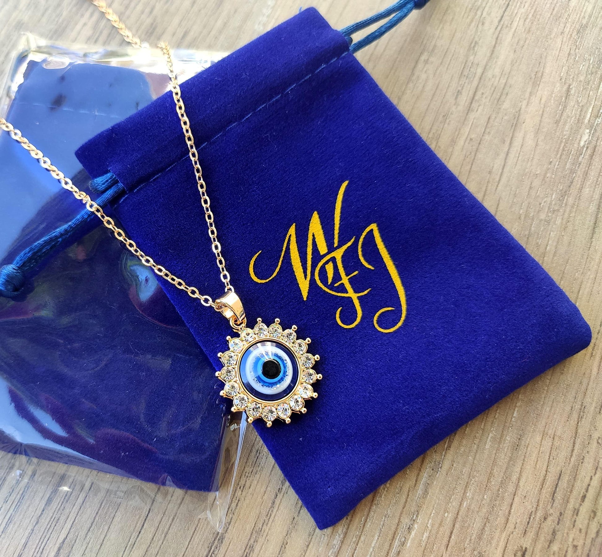 Adjustable gold chain necklace with protective eye pendant