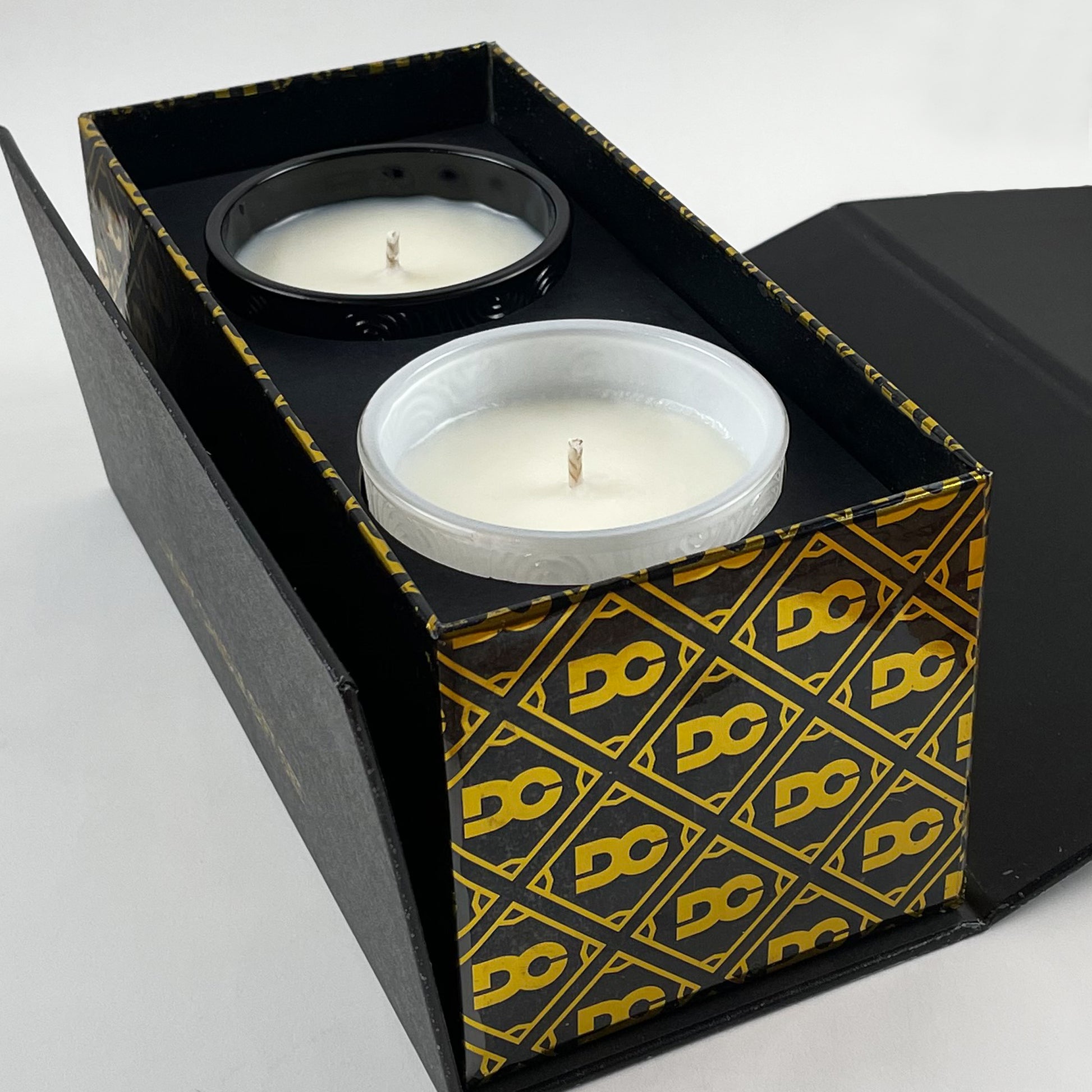 Two candles in a decorative box with a geometric pattern on a white background