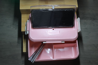 Lunch box lid used as phone stand while eating a meal