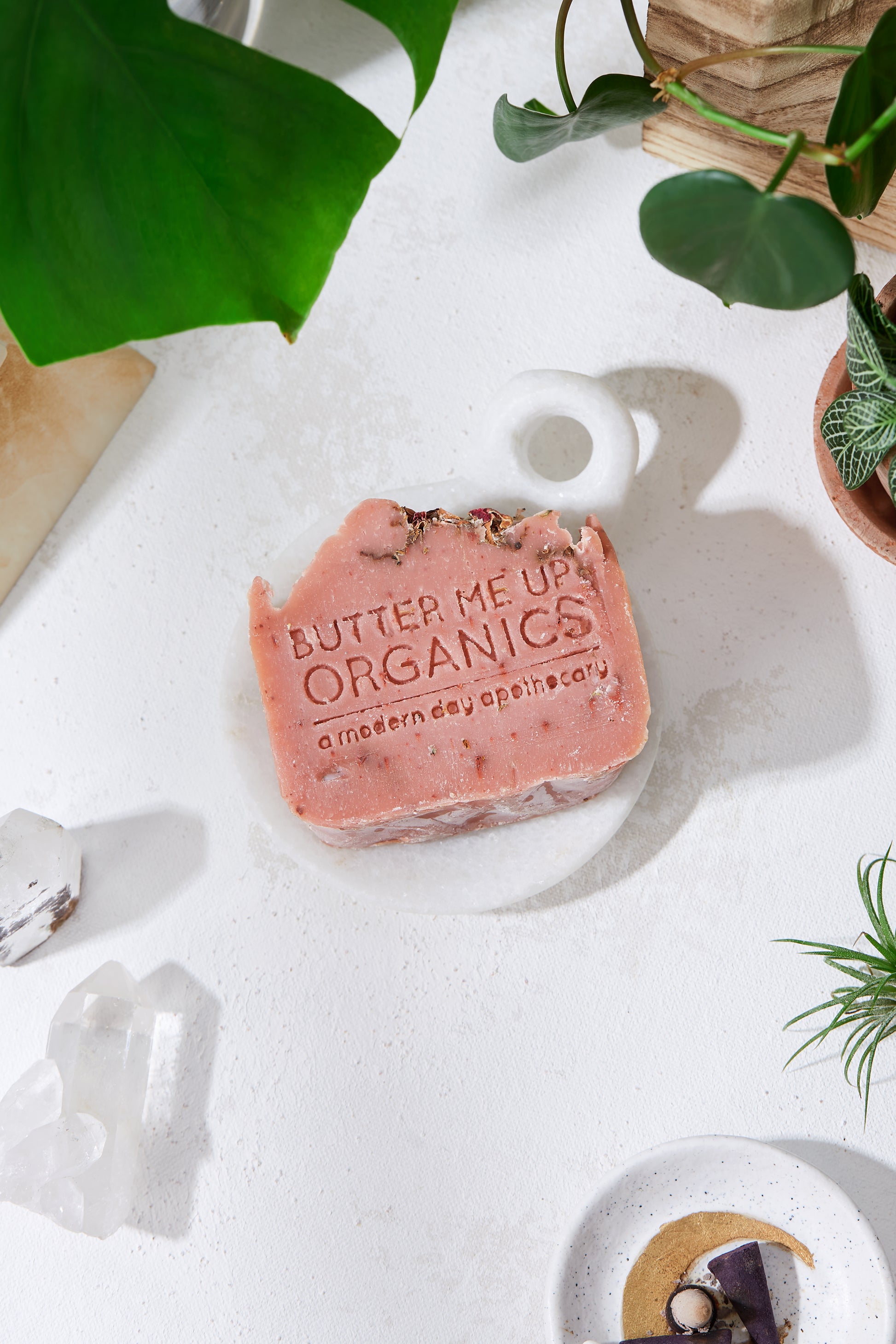 Krombee Pink soap bar with 'Butter Me Up Organics' branding on a white surface with plants and crystals.