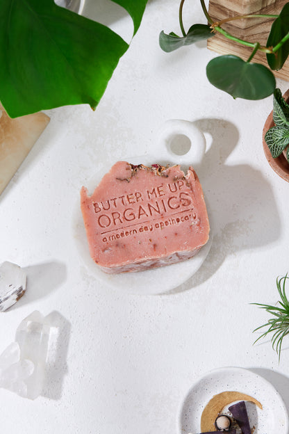 Krombee Pink soap bar with 'Butter Me Up Organics' branding on a white surface with plants and crystals.