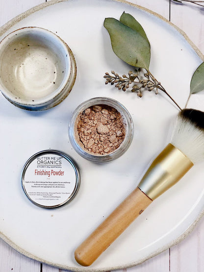 Organic translucent finishing powder in glass jar with metal lid