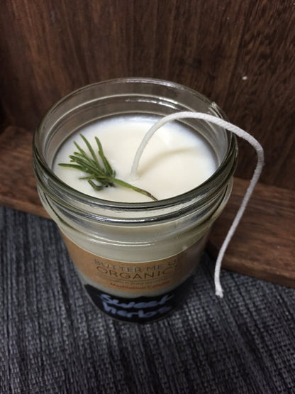 Candle in a glass jar with a wooden background