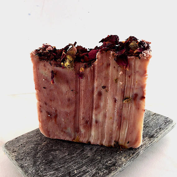 Krombee Bar of soap with dried herbs on a gray stone surface