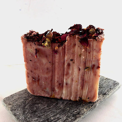 Krombee Bar of soap with dried herbs on a gray stone surface