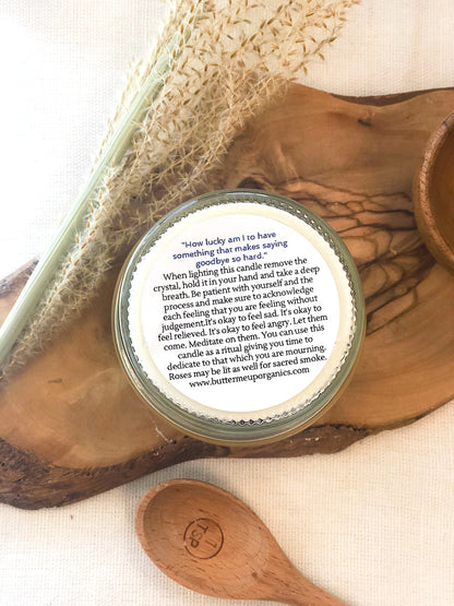 Krombee Remembrance Candle Jar with a label on a wooden surface with a spoon and crystal